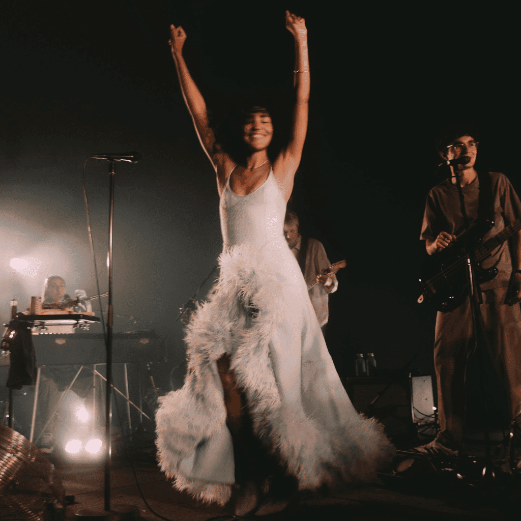 LXURI - Olivia Dean wearing a stunning outfit during a live performance, reflecting her soulful fashion aesthetic.